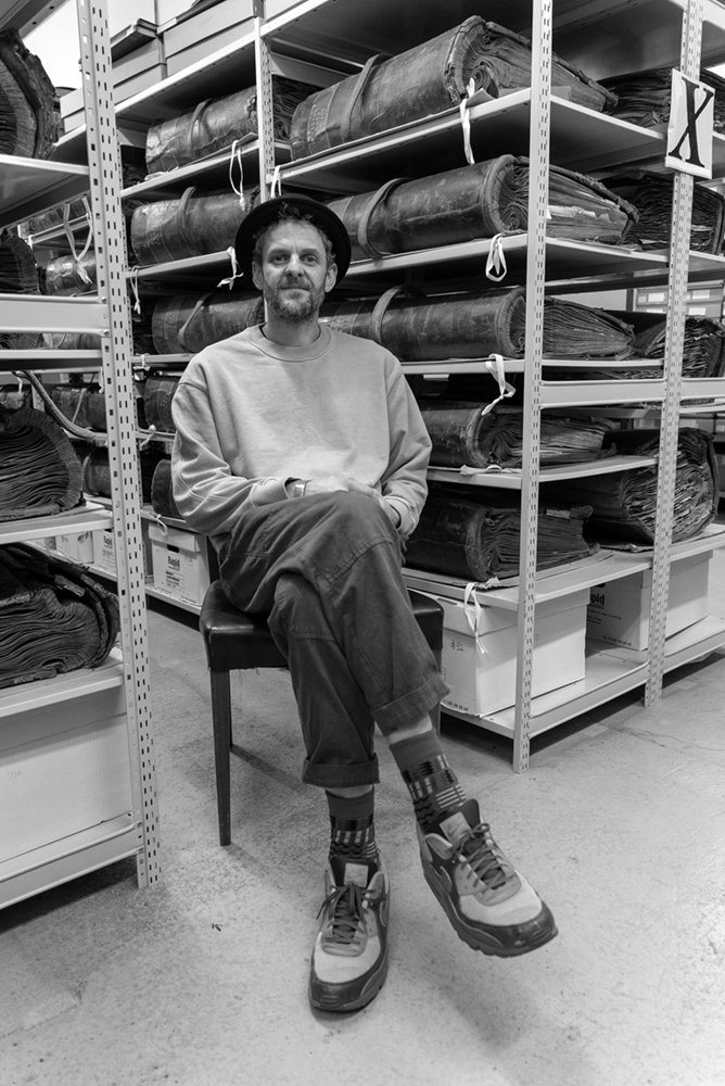 John House, seated in the archive stacks